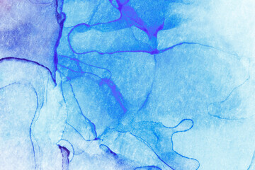 Macro close-up of blue alcohol ink layers and splashes, abstract background. Fluid ink, colorful full frame textured background. Vibrant color. Art for design.