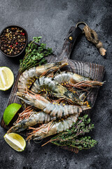Raw black tiger prawns, shrimps and spices.  Black background. Top view