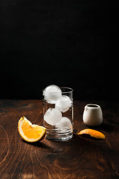 Ingredients for espresso tonic with orange juice recipe. A highball glass with ice, orange wedge, zest and espresso in a white can