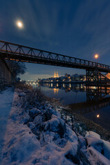 Cathedral, Eiserner Steg and old town of Regensburg on the danube river in winter with fresh snow and full moon