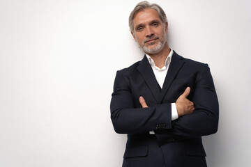 Handsome middle-aged man in suit posing against grey background