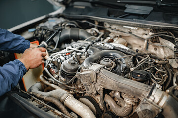 Auto mechanic man checks car engine under the hood