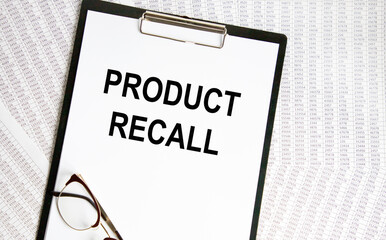 On the tablet for writing the text Product Recall, next to the glasses, the background are reports.