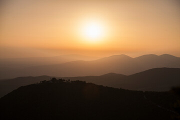Panorama of a hilly landscape with several levels: romantic sunset in Greece in warm colors