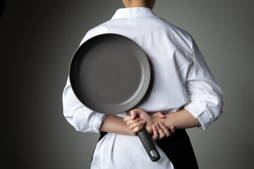 chef with hand hold pan on grey background
