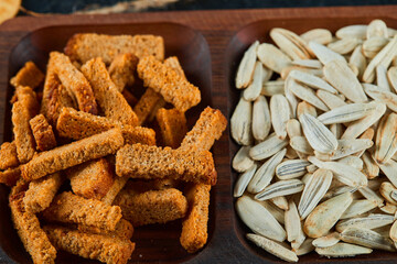 Crackers and sunflower snacks on wooden plate