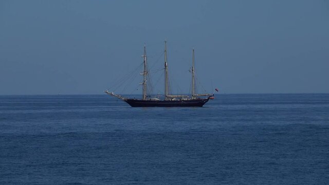 A schooner barque sailing vessel with three masts at anchor in calm seas of the coast of Australia.