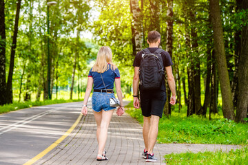 Obraz premium A guy and a girl walk along the path in the city Park 