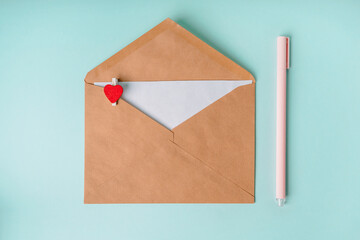 Love envelope with a clothespin in the shape of a heart on a blue background. Romantic background, the concept of the day of love