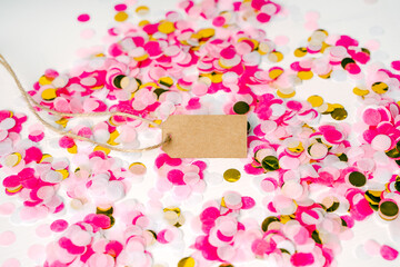 Craft tag with space for text on a colored background with festive confetti. The concept of congratulations for your loved ones or an announcement about a discount