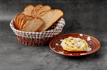 A plate of spaghetti stuffed with chicken fillet and cheese on the table next to a basket of bread. Decoration with drops of cream sauce. Gray texture background top view. Menu Of Dishes