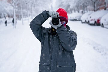 Teenage girl takes photos with her camera on the snow