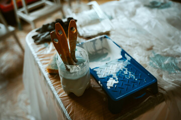 Workplace after painting furniture, brushes in water and other paint accessories