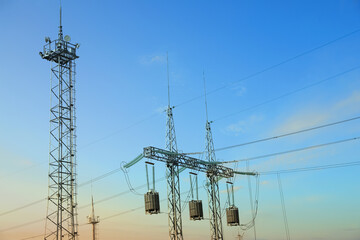 High voltage towers against blue sky on sunny day