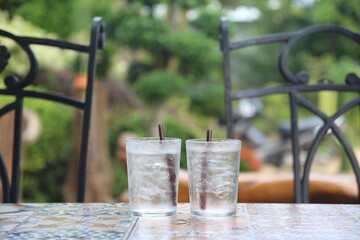 2 glasses of cold water on the table in cafe garden background