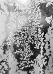 Ornamental hoarfrost pattern on the window glass. Crystal frozen ice texture 