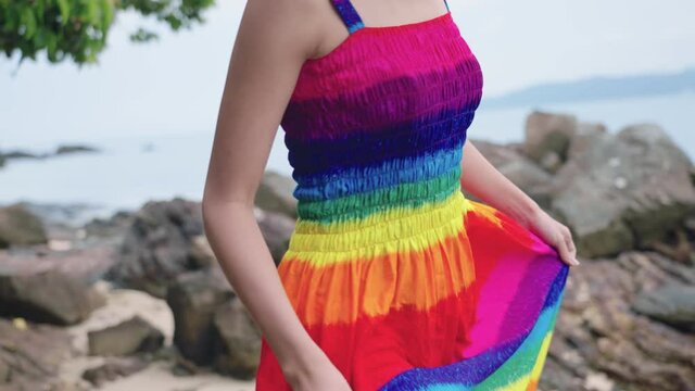 Close-up of female mid body walking forward on a tropical rocky coastline, a blue sky and sea rocks on the summertime, carefully hike on a the slippery wet stones, relaxing self balance development 
