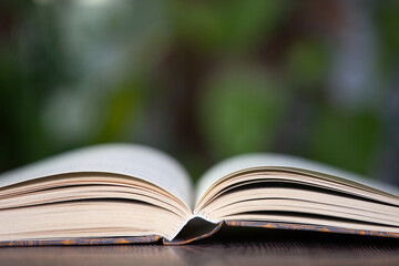 A book opened before the background of green virtual