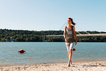 Carefree woman walking at the beach during summer day.