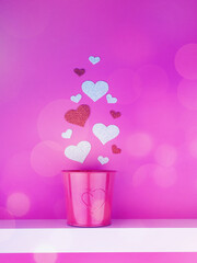 Valentine's day concept, silver and red heart and red iron pot stands on a white shelf