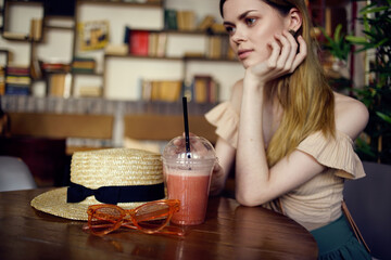 Woman sitting in a restaurant at the table glass of juice rest pensive look