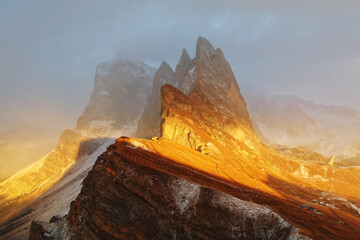 Odle mountain range, Seceda peak between clouds in beautiful sunset scene, Val Gardena in Dolomites - 408501105