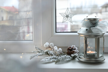 Fototapeta premium Beautiful Christmas lantern and other decorations on window sill
