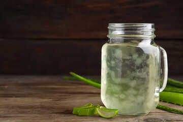 Fresh aloe drink in mason jar on wooden table. Space for text