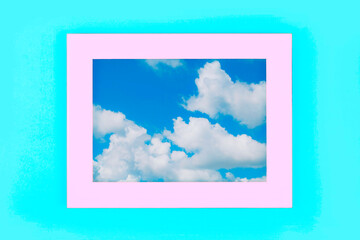 Simple pink frame with cloudy blue sky on pastel blue background. Minimal border composition.