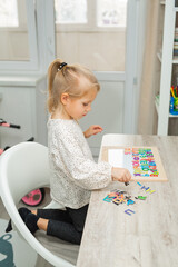 beautiful little girl playing educational game at home 
