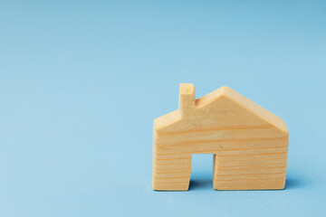 Wooden house miniature on blue background close up