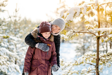 Family winter walk in the forest. Raising a child, family habits. Mother and daughter are having...