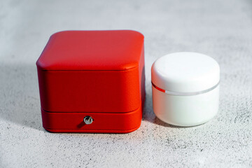 Luxury red box and a white cosmetic jar. Product concept