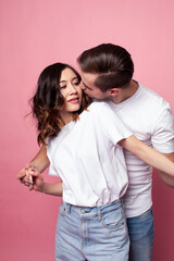 young cheerful caucasian couple together having fun on pink background, guy ang girl modern relationship, lifestyle people concept