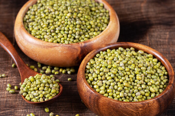 Obraz premium Mung. Green mung beans in a bowl on a brown wooden table. Legume plant for a healthy diet 
