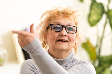 Head shot mature woman looking at camera and talking, grandmother chatting with relative online, making video call, middle aged blogger recording vlog, teacher speaking to webcam, distance lecture