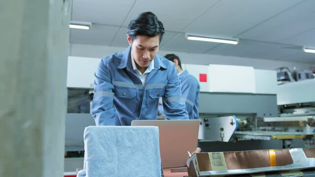 specialist worker engineer team control and operate printing package lable machine with computer screen with concentrate and focus industrial factory machinery ideas concept