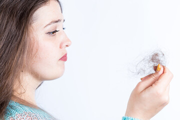 Lost hair in hand. Girl with hair problem on a white.