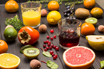 Glasses of orange and grapefruit juice among tropical fruits.