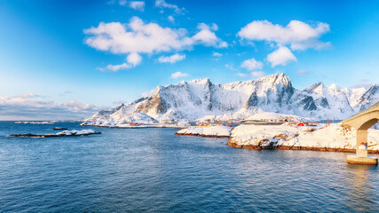 Naklejka premium Fabulous winter view of Reine and Sakrisoya villages seen from Hamnoy and snowy mountaines in background .