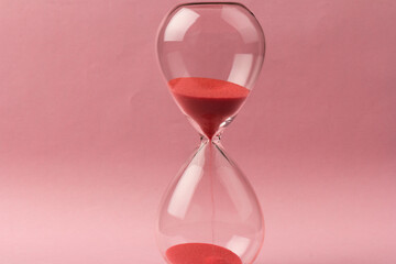 Crystal hourglass on pink background as a concept of passing time for business term, urgency and outcome of time.