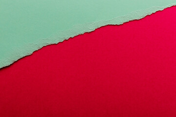 Ripped paper, space for copy. Torn green paper on red background.