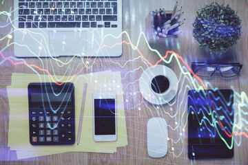 Double exposure of forex chart hologram over desktop with phone. Top view. Mobile trade platform...