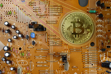 golden bitcoin coin on Printed circuit board. The concept of earning, mining cryptocurrency