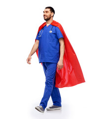 healthcare, profession and medicine concept - happy smiling doctor or male nurse in blue uniform and red superhero cape with stethoscope over white background