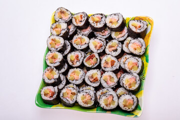 Top view of stack of Japanese sushi maki roll plate. Served in Japanese bar restaurant with chopstick