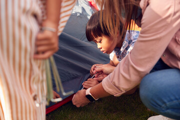Asian Mother With Children In Garden At Home Putting Up Tent For Camping Trip Together