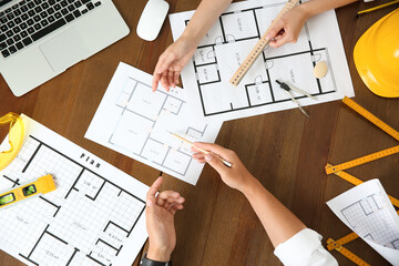 People working with construction drawings and tools  at wooden table, top view