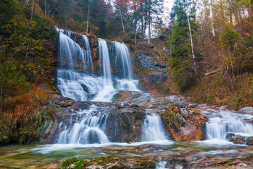 Fototapeta na wymiar Large waterfall in beautiful autumn colors in Berchtesgaden National Park near the German-Austrian border, Allgau Alps, Bavaria province
