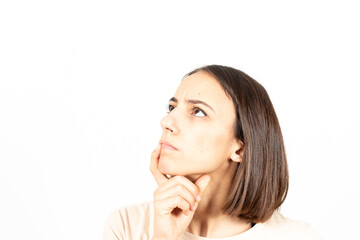 Naklejka premium A young hispanic woman looking up and thinking on an idea with serious gesture.